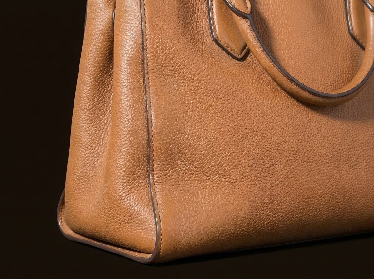 Le même sac après soin : moisissure et auréoles disparues, cuir nourri et uniforme, tranche reprise à la main.